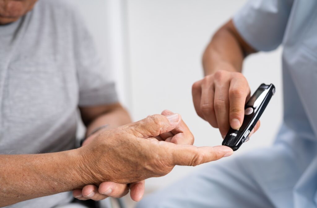 A caregiver checking a senior with diabetes blood sugar level