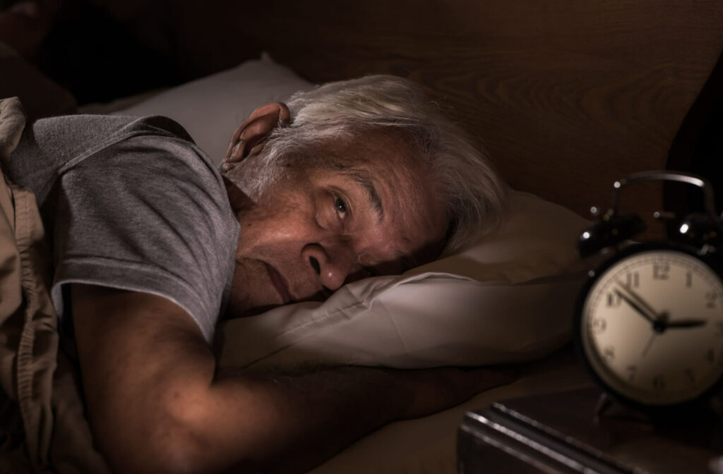 A close-up of an elderly man having a hard time sleeping. Sleep disorders are common symptoms of Lewy Body Dementia.