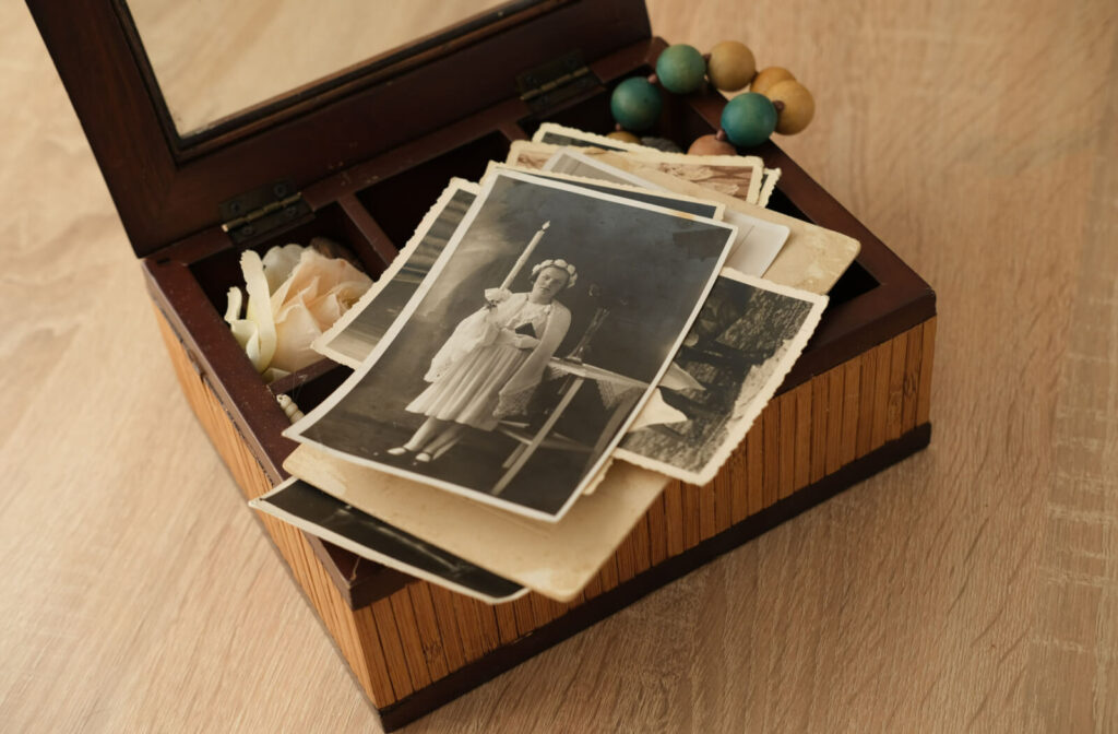 Vintage wooden box filled with old photographs and art memorabilia.