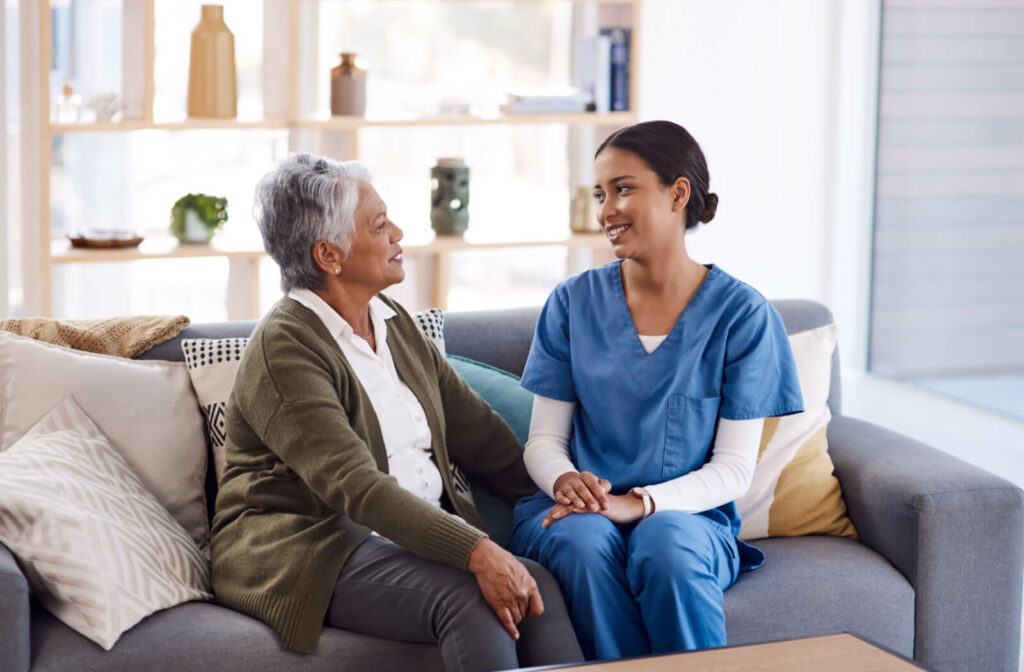 An older adult woman speaking to a nurse.